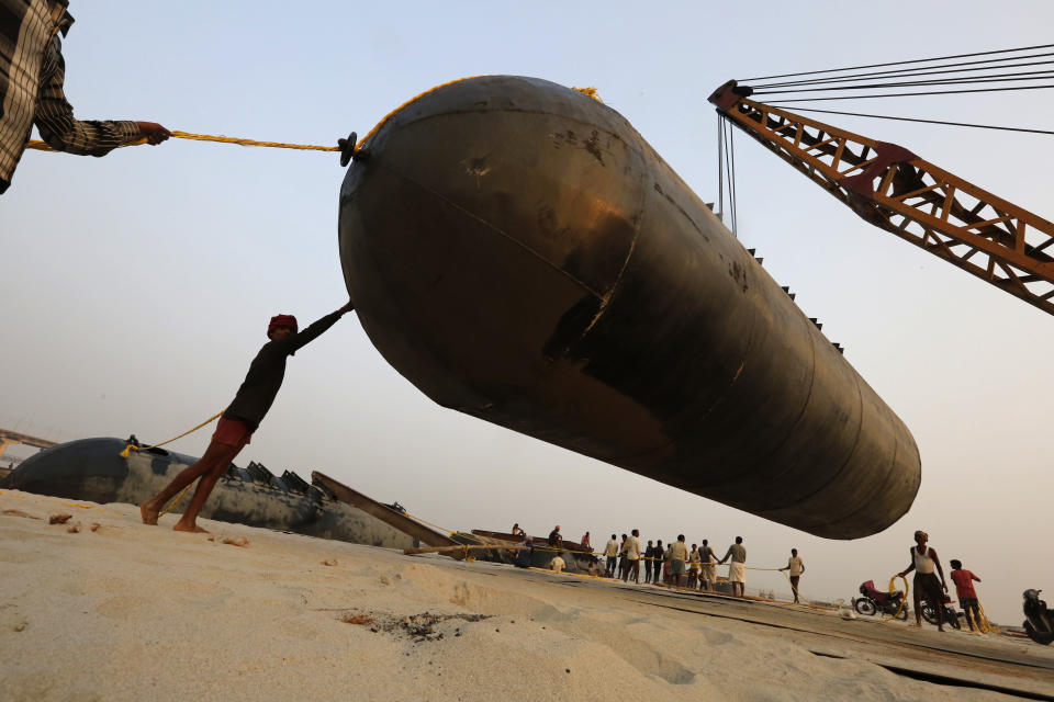 In this Monday, Nov. 12, 2018, file photo, Indian laborers pull a pontoon buoy as they build a floating pontoon bridge over the river Ganges for the upcoming Kumbh Mela festival, in Allahabad, India. A 45 days festival starting from January 2019, where millions of Hindu devotees are expected to attend with the belief that taking a dip in the waters of the holy river will cleanse them of their sins. (AP Photo/Rajesh Kumar Singh, File)