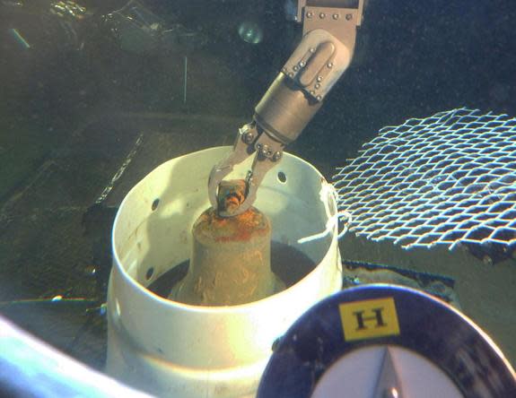 The manipulator arm of HURL's manned submersible places the I-400's bronze bell into a collection basket.