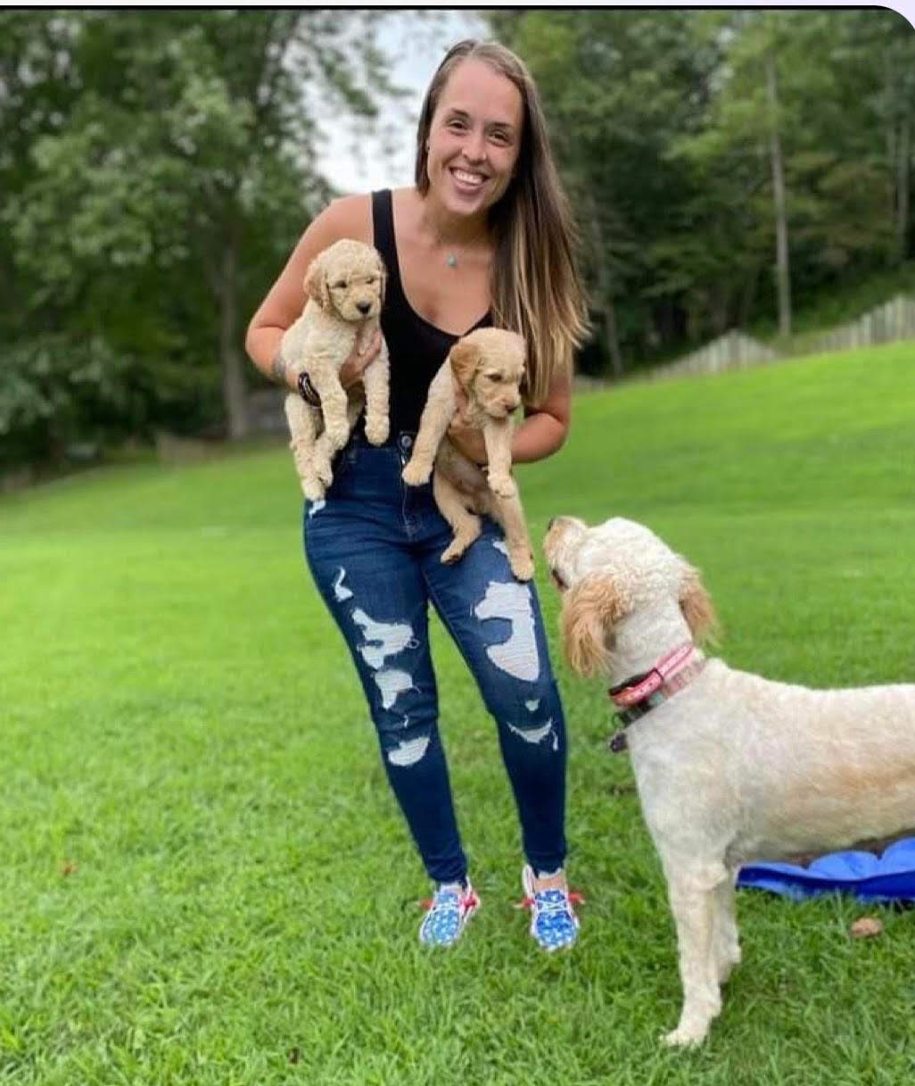 Corrine Henry holds two of the goldendoodle puppies for which she found loving homes through her operation, The Doggone Doodle Co.