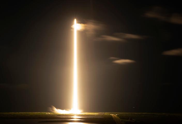 A long exposure shows the SpaceX Falcon 9 rocket with Crew Dragon capsule as it flies into orbit.