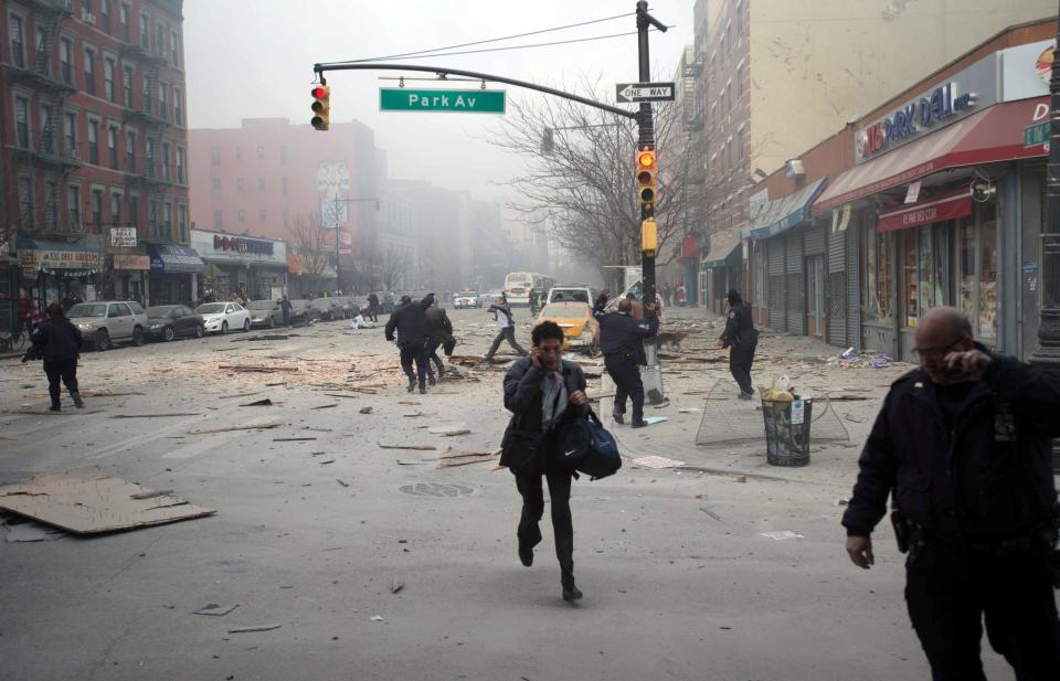People run after an explosion and building collapse in the East Harlem neighborhood of New York, Wednesday, March 12, 2014. The explosion leveled an apartment building, and sent flames and billowing black smoke above the skyline. (AP Photo/Jeremy Sailing)