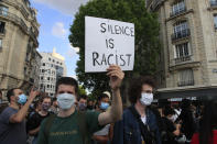 A protester holds a poster during a demonstration Tuesday, June 2, 2020 in Paris. Thousands of people defied a police ban and converged on the main Paris courthouse for a demonstration to show solidarity with U.S. protesters and denounce the death of a black man in French police custody. The demonstration was organized to honor Frenchman Adama Traore, who died shortly after his arrest in 2016, and in solidarity with Americans demonstrating against George Floyd's death. (AP Photo/Michel Euler)