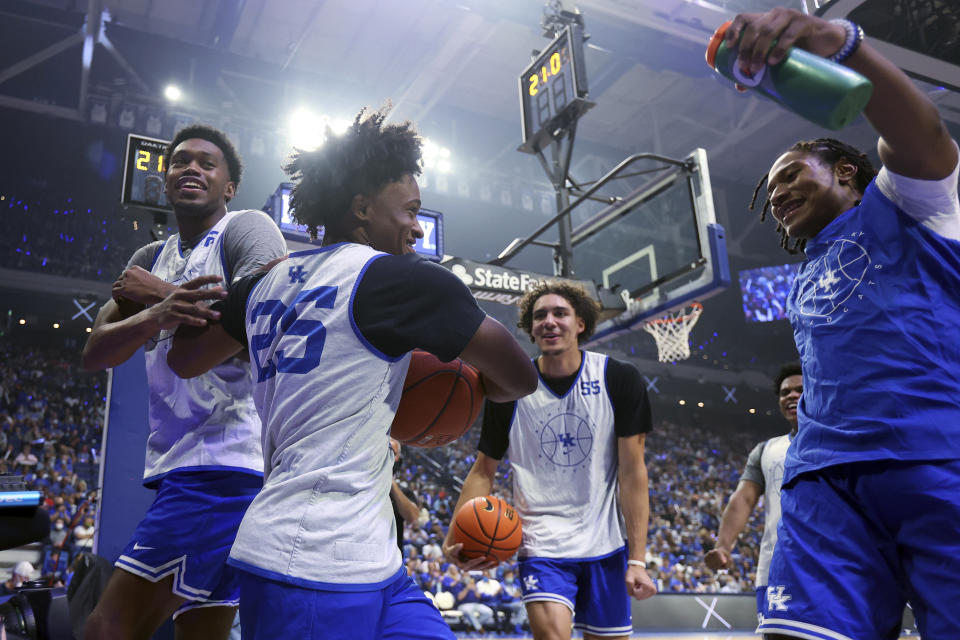 Kareem Watkins (25) is congratulated by teammates after his dunk during Kentucky's NCAA college basketball season kickoff event, Big Blue Madness, in Lexington, Ky., Friday, Oct. 15, 2021. (AP Photo/James Crisp)