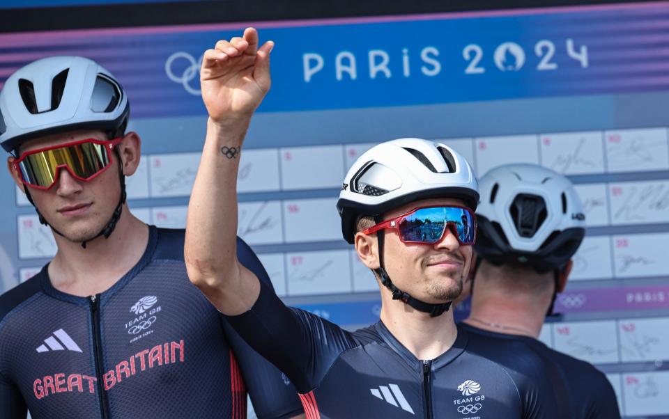 Tom Pidcock waves to spectators, next to Josh Tarling, in Paris before the men's Olympic road race.