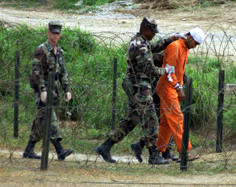 Military Police at camp X-Ray on the Naval Base at Guantanamo Bay, Cuba, bring a detainee to an interrogation room, February 6, 2002. There are one hundred and fifty eight detainees in Guantanamo Bay. (Marc Serota/Reuters)