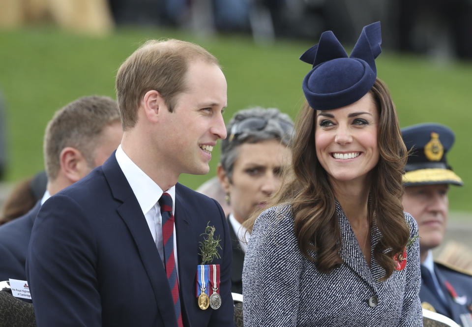 Britain's Prince William and his wife Kate, the Duchess of Cambridge, chat during the Anzac Day parade at the Australian War Memorial in Canberra, Australia, Friday, April 25, 2014. The Duke and Duchess attended the memorial as the last engagement of their three week state visit of New Zealand and Australia with their son Prince George.(AP Photo/Rob Griffith)