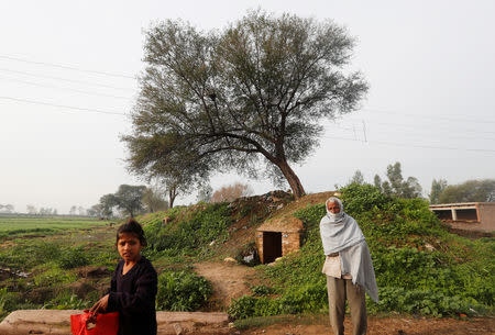 A man and a girl stand near a bunker at a village near the border with Pakistan in Ranbir Singh Pura sector near Jammu March 1, 2019. REUTERS/Adnan Abidi