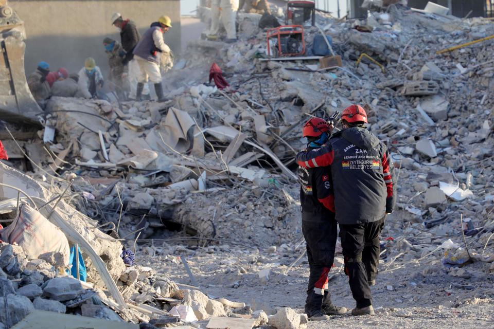 Members of the Zeytinburnu Municipality Search and Rescue Team (ZAK) confort themselves by the rubble of collapsed buildings in Nurdagi, near Gaziantep, on February 13, 2023, as rescue teams began to wind down the search for survivors, a week after an earthquake devastated parts of Turkey and Syria leaving more than 35,000 dead and millions in dire need of aid.