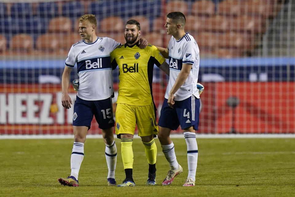 Vancouver Whitecaps' Andy Rose (15) and Ranko Veselinovic (4) celebrate with goalkeeper Maxime Crepeau (16) following their MLS soccer game against the Portland Timbers, Sunday, April 18, 2021, in Sandy, Utah. (AP Photo/Rick Bowmer)