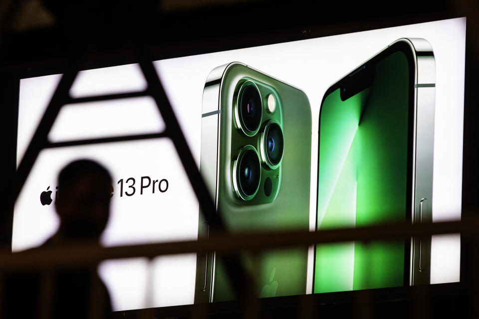 A person passes a large outdoor advertisement for the Apple iPhone 13 Pro on April 11, 2022 in Wuhan, Hubei province, China. (Photo by Getty Images)