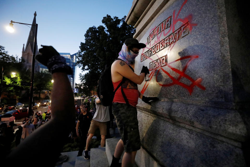 Image: A protester defaces a Confederate monument during nationwide unrest following the death in Minneapolis police custody of George Floyd, in Raleigh (Jonathan Drake / Reuters)