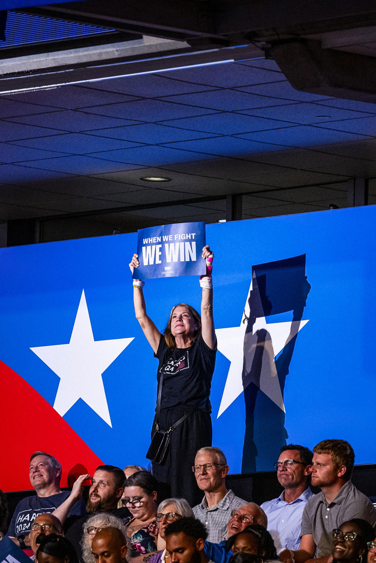 A woman holds a sign with the slogan “When We Fight We Win” during a campaign rally (Pete Kiehart for NBC News)