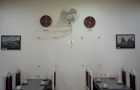 FILE PHOTO: Clocks show the half-hour time difference between India and Pakistan at a restaurant at the Wagah-Attari border crossing, Pakistan, March 15, 2019. REUTERS/Alasdair Pal