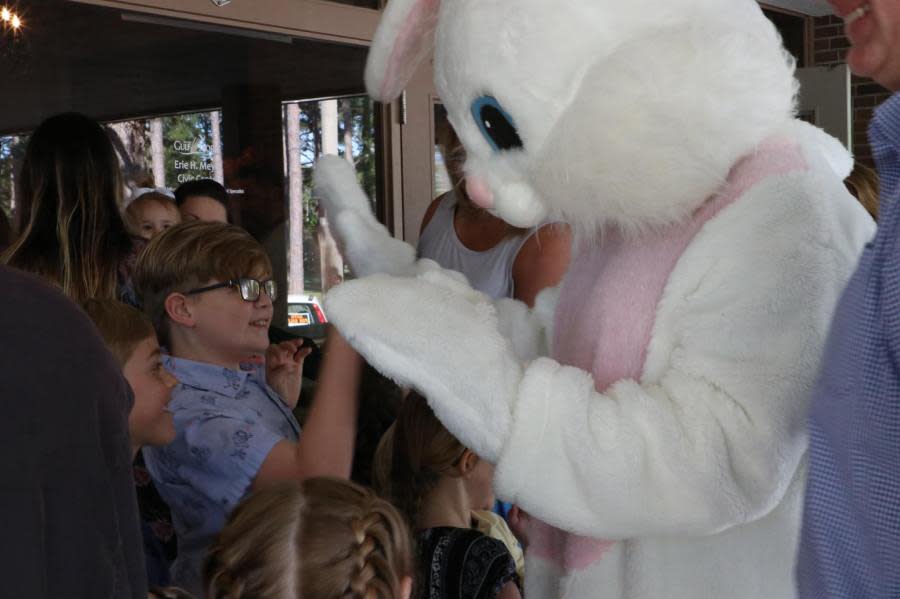 Photo of kids high fiving the Easter Bunny