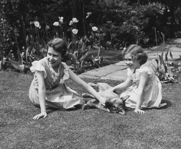 Princess Elizabeth and her younger sister, Princess Margaret, petting a corgi in 1936. (Photo: Lisa Sheridan/Studio Lisa/Hulton Archive/Getty Images)