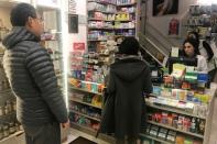 People line up at a pharmacy to purchase N95 face masks in advance of the potential coronavirus outbreak in the Manhattan borough of New York City