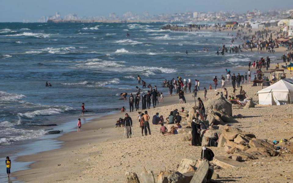 Internally displaced Palestinians flock to Rafah beach, near the border with Egypt, in Rafah, amid Israeli calls for resident to 'temporarily'  evacuate to an expanded humanitarian area