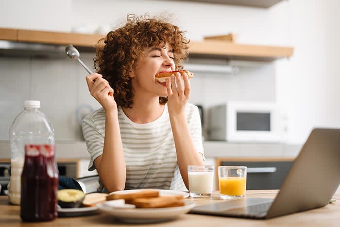 mujer desayunando una tostada