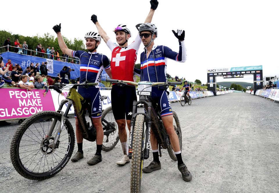 Switzerland's Joris Ryf, center, celebrates after winning the Men's Elite E-MTB Cross-Country race alongside France's Hugo Pigeon, left, who finished second and France's Jerome Gilloux, right, who finished third during day seven of the 2023 UCI Cycling World Championships at the Glentress Mountain Bike Trail Center in Glasgow, Scotland, Wednesday, Aug. 9, 2023. (Jane Barlow/PA via AP)
