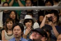People watch women fight during a Stardom female professional wrestling show at Korakuen Hall in Tokyo, Japan, July 26, 2015. REUTERS/Thomas Peter