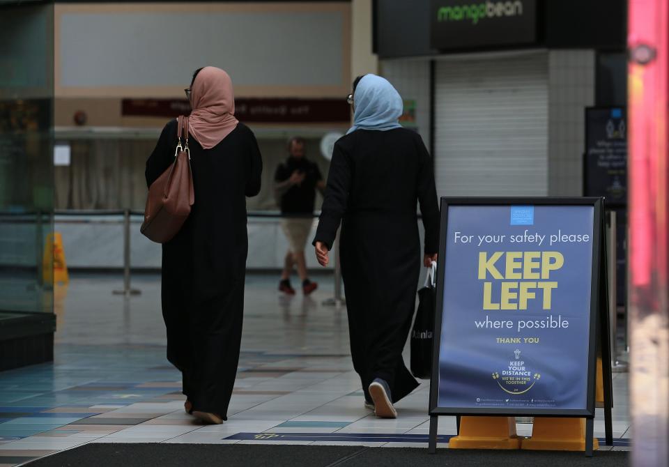 Women walk in a socially distanced one-way system, implemented due to COVID-19, inside a shopping centre in Oldham, Greater Manchester, northwest England on August 20, 2020. - Oldham, as of Thursday, has one of the highest rates of new COVID-19 infections, and could be subject to a imposed Local Lockdown to prevent the spread of the novel coronavirus. (Photo by Lindsey Parnaby / AFP) (Photo by LINDSEY PARNABY/AFP via Getty Images)