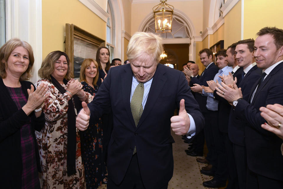 Britain's Prime Minister Boris Johnson is greeted by staff as he returns to 10 Downing Street, London, after meeting Queen Elizabeth II at Buckingham Palace and accepting her invitation to form a new government, Friday Dec. 13, 2019. Boris Johnson led his Conservative Party to a landslide victory in Britain’s election that was dominated by Brexit. (Stefan Rousseau/PA via AP)