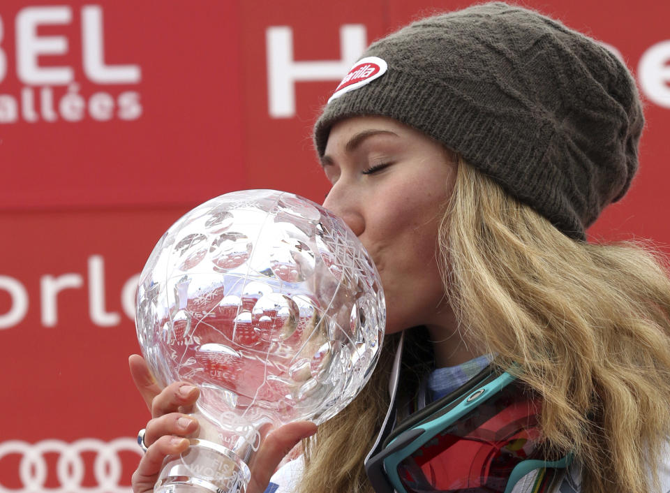 FILE - Mikaela Shiffrin, of the United States, kisses the alpine ski, women's World Cup slalom discipline trophy, at the World Cup finals in Meribel, France, Saturday, March 21, 2015. Mikaela Shiffrin has matched Lindsey Vonn’s women’s World Cup skiing record with her 82nd win at the women's World Cup giant slalom race, in Kranjska Gora, Slovenia, on Sunday, Jan. 8, 2023. (AP Photo/Armando Trovati, File)