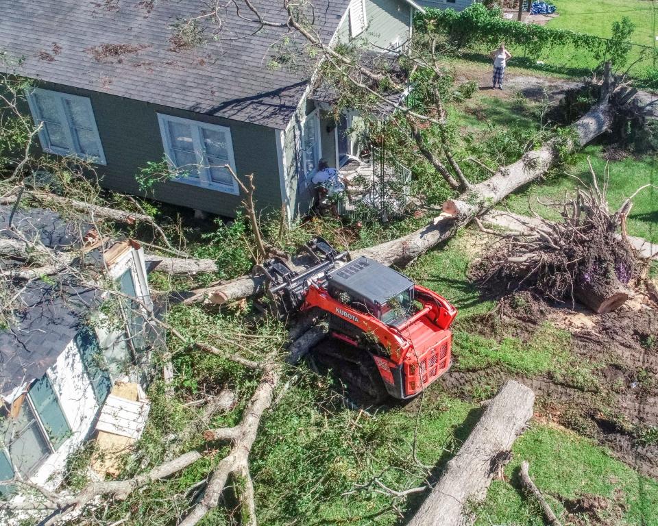 Arborist Michael McDonald on Saturday clears trees that fell on houses after Hurricane Delta made landfall in, Louisiana.