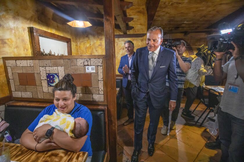 NORTH HOLLYWOOD, CA - JUNE 06: Stephanie Quintero of Lancaster holding her newborn Natalia is eating lunch. Mayoral candidate Rick Caruso and Joe Buscaino, Los Angeles City stop in and talk at the Salsa & Beer restaurant on Monday, June 6, 2022, in North Hollywood, CA. Mayoral candidate Rick Caruso is stopping in on several locations on the last day before Tuesday's Primary election. (Francine Orr / Los Angeles Times)