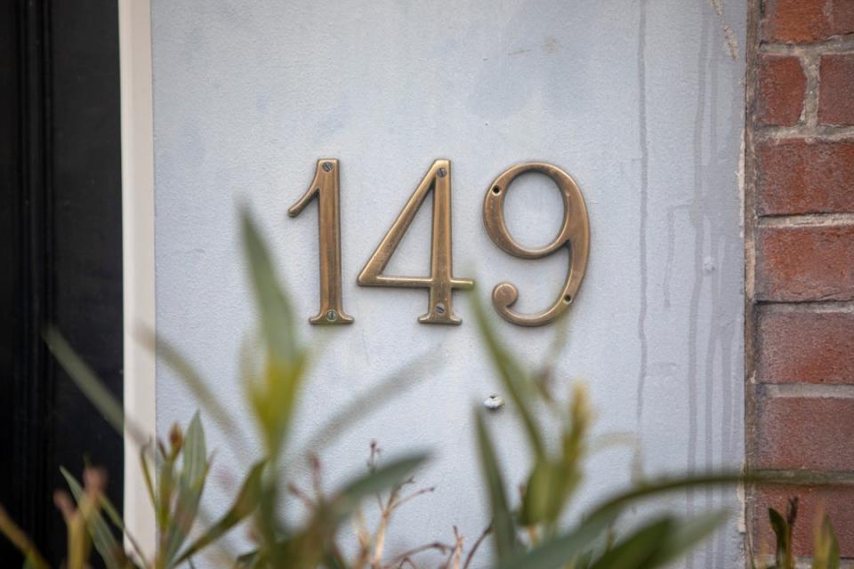 Large gold house numbers 149 next to the front door.