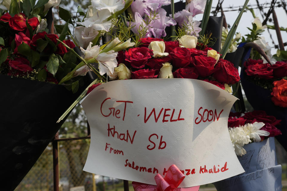 A bouquet with a "get well soon" message is placed by well-wisher over the wall of a hospital where former Pakistani Prime Minister Imran Khan is being treated for a gunshot wound in Lahore, Pakistan, Friday, Nov. 4, 2022. Khan who narrowly escaped an assassination attempt on his life the previous day when a gunman fired multiple shots and wounded him in the leg, is listed in stable condition after undergoing surgery at a hospital, a senior leader from his party said Friday. (AP Photo/K.M. Chaudhry)