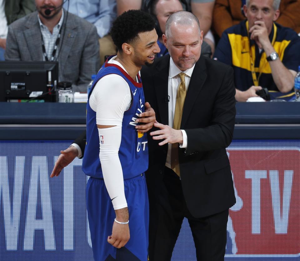 Denver Nuggets guard Jamal Murray, left, jokes with head coach Michael Malone during a break in the action against the San Antonio Spurs in the second half of Game 5 of an NBA basketball first-round playoff series Tuesday, April 23, 2019, in Denver. The Nuggets won 108-90. (AP Photo/David Zalubowski)