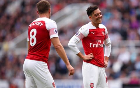 Aaron Ramsey while Mesut Ozil stare at each other - Credit: getty images