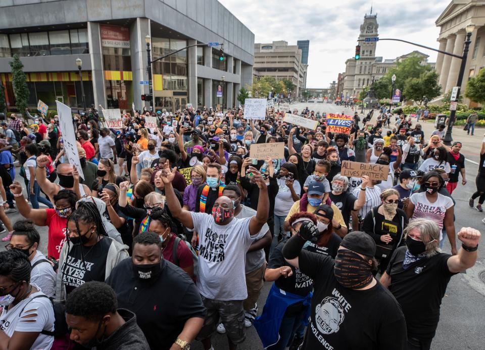 Protesters squeeze between Alice barricade as they march from Jefferson Square to the NuLu district in Louisville. Sept. 25, 2020.