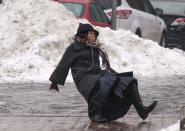 A woman falls while slipping on ice during freezing rain on Roosevelt Island, a borough of Manhattan, in New York January 5, 2014. New York City was hit on Friday by the first severe winter storm of 2014 and was still in the grip of sub-freezing weather on Sunday morning. The woman got up and walked away from the fall. REUTERS/Zoran Milich (UNITED STATES - Tags: SOCIETY ENVIRONMENT TPX IMAGES OF THE DAY)