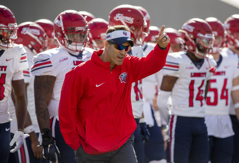 Liberty coach Jamey Chadwell leads his team onto the field to face UTEP in an NCAA college football game on Saturday, Nov. 25, 2023, in El Paso, Texas. Liberty became the first Division I team from Virginia to win 12 games in a season. (AP Photo/Andres Leighton)