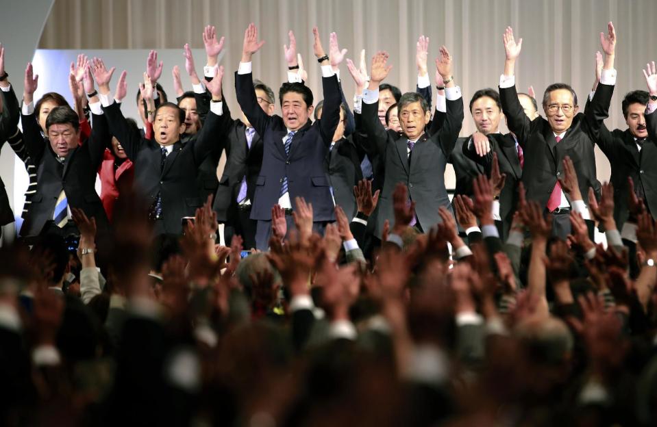 Japanese Prime Minister Shinzo Abe, center, shouts traditional "Banzai (long life)" cheers with lawmakers and members of his ruling Liberal Democratic (LDP) Party during its annual convention at a hotel in Tokyo, Sunday, March 5, 2017. Japan's ruling party approved a change in party rules Sunday that could pave the way for Prime Minister Shinzo Abe to become the country's longest-serving leader in the post-World War II era. (AP Photo/Shizuo Kambayashi)