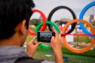 <p>In this photograph taken on August 9, 2016, an Indian boy takes a photograph of the Olympics rings during a live screening of the Rio 2016 Olympics at a park in New Delhi. Around a giant screen showing the Olympics in a central New Delhi park, young Indians chat, take selfies or snooze in the late afternoon heat, glancing only occasionally at the heroic sporting feats on display. India is the world’s second most populous country and has ambitions to become a global superpower. But when it comes to the Olympics it remains a minnow — a status matched by the public’s supreme indifference to the Games. </p>