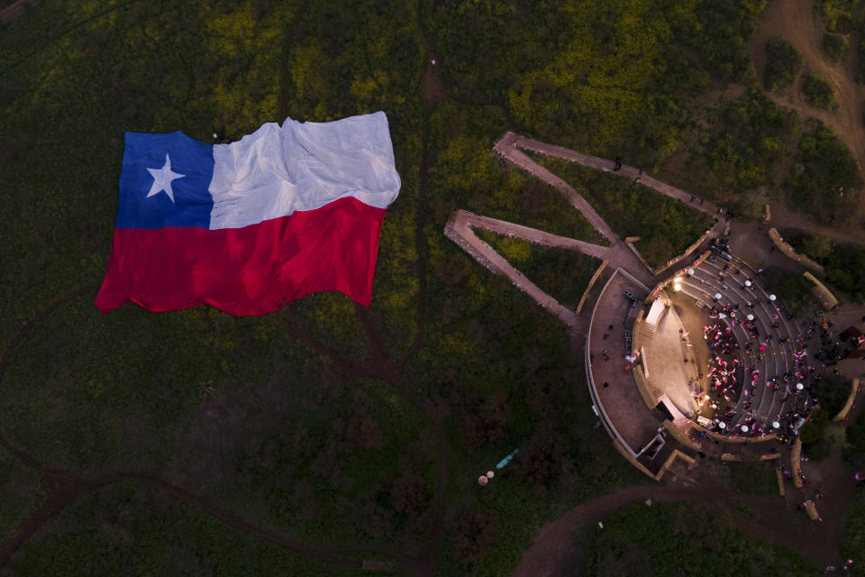 A giant national flag is displayed as demonstrators rally against the proposed new Constitution, at the Pablo Neruda amphitheater in Santiago, Chile, Thursday, Sept. 1, 2022. Chileans have until the Sept. 4 plebiscite to study the new draft and decide if it will replace the current Magna Carta imposed by a military dictatorship 41 years ago. (AP Photo/Matias Basualdo)