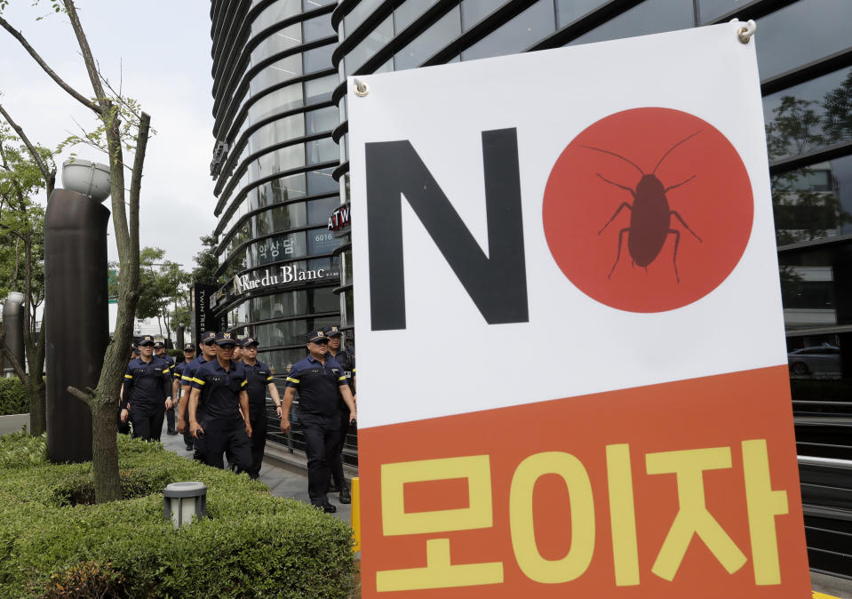 South Korean police officers patrol for possible rallies against Japan near a building which houses Japanese embassy in Seoul, South Korea, Thursday, Aug. 1, 2019. Police say a 72-year-old South Korean man is in critical condition after setting himself ablaze in downtown Seoul, apparently to express his anger toward Japan amid worsening tensions between countries over trade and wartime history. The signs read: "Gather." (AP Photo/Ahn Young-joon)