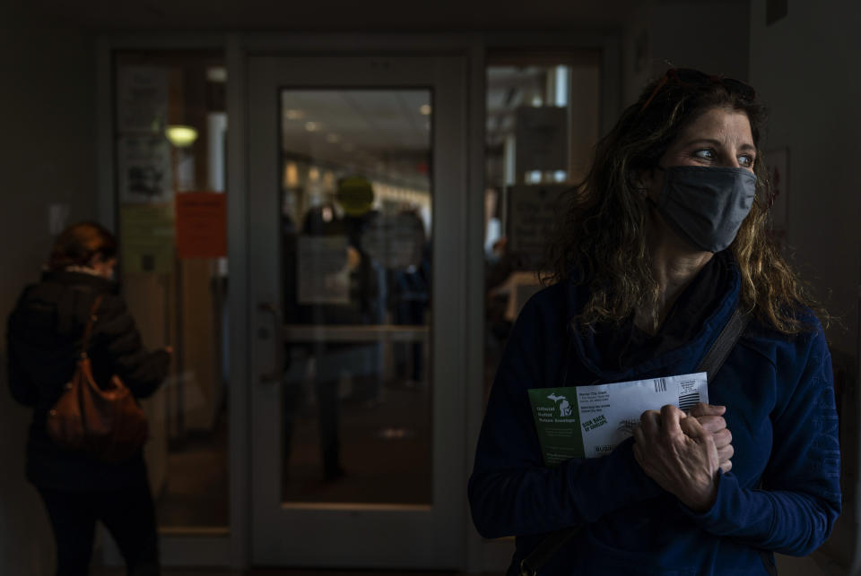 Diane Spiteri clutches her absentee ballot before dropping it off at the city clerk's office in Warren, Mich., Wed, Oct. 28, 2020. "I just can't wait until the whole thing is over. And I think it's long from over, even after Tuesday. There's just so much anxiety," said Spiteri, who cast her ballot last week for Biden. As the traditional Election Day closes in, Americans are exhausted from constant crises, on edge because of volatile political divisions and anxious about what will happen next. (AP Photo/David Goldman)