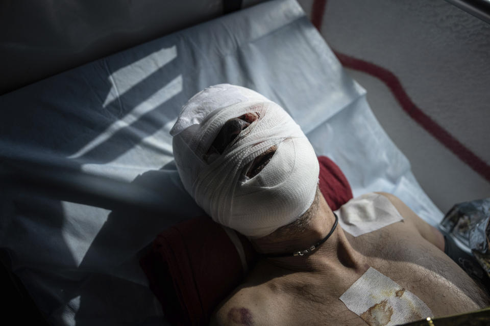 An injured Ukrainian soldier lies on a bed inside a special medical bus during an evacuation by volunteers from the Hospitallers paramedic organisation in Donetsk region, Ukraine, Wednesday, March 22, 2023. (AP Photo/Evgeniy Maloletka)