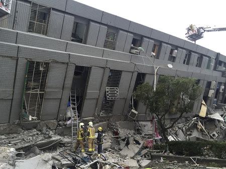 Rescue personnel work at a damaged building after an earthquake in Tainan, southern Taiwan, February 6, 2016. REUTERS/Pichi Chuang