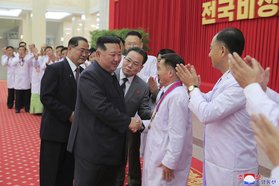 FILE - In this photo provided by the North Korean government, North Korean leader Kim Jong Un shakes hands with a health official in Pyongyang, North Korea, Wednesday, Aug. 10, 2022. North Korea on Friday, Aug. 26, 2022, said the latest fever cases detected in its border region with China were tested to be influenza, not coronavirus infections as initially feared. The content of this image is as provided and cannot be independently verified. Korean language watermark on image as provided by source reads: "KCNA" which is the abbreviation for Korean Central News Agency. (Korean Central News Agency/Korea News Service via AP)