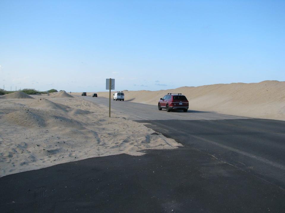 Traffic on N.C. 12 travels north of Rodanthe through sand dunes that often wash onto the roadway during high-tide events.
