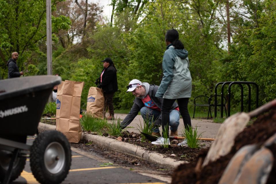 Volunteers clean up debris along the Lansing River Trail, Saturday morning, May 11, 2024, while other plant plants s part of the 30th Annual BWL Adopt a River cleanup.