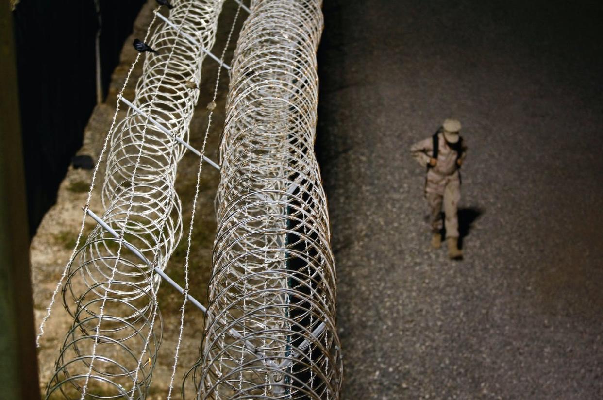 <span class="caption">Two detainees at Guantanamo are among those who told ICC investigators they were tortured at CIA 'black sites' in Afghanistan in 2003 and 2004.</span> <span class="attribution"><a class="link " href="https://www.gettyimages.com/detail/news-photo/navy-sailor-walks-along-a-fence-at-a-camp-for-detainees-at-news-photo/92477311?adppopup=true" rel="nofollow noopener" target="_blank" data-ylk="slk:ohn Moore/Getty Images;elm:context_link;itc:0;sec:content-canvas">ohn Moore/Getty Images</a></span>