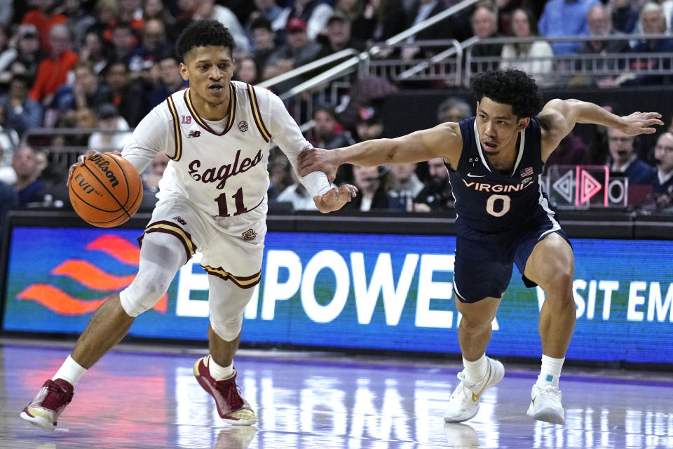 Boston College guard Makai Ashton-Langford (11) tries to break free from Virginia guard Kihei Clark (0) on a drive to the basket during the second half of an NCAA college basketball game, Wednesday, Feb. 22, 2023, in Boston. (AP Photo/Charles Krupa)