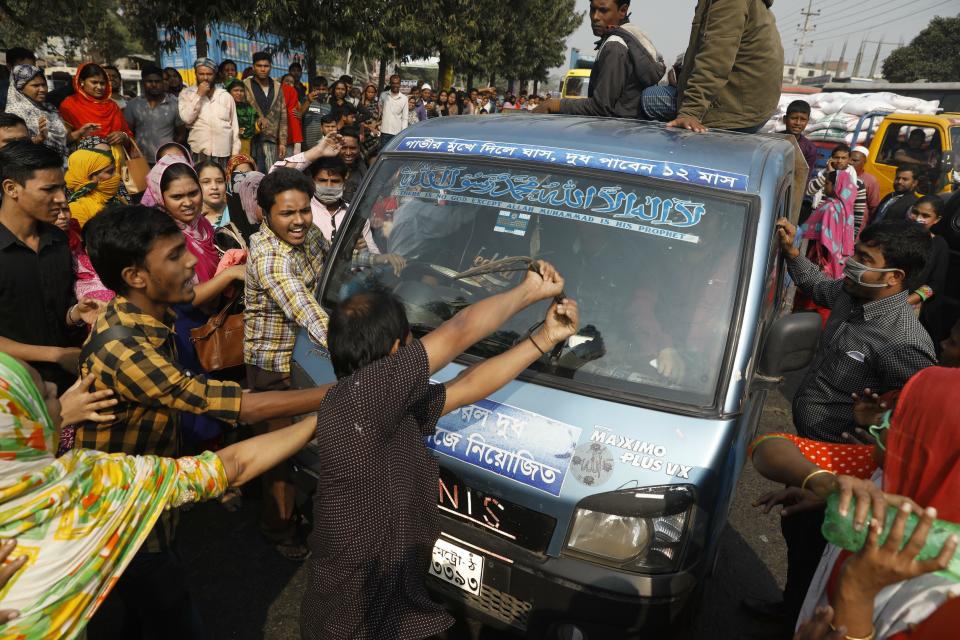 FILE - In this Wednesday, Jan. 9, 2019, file photo, Bangladeshi garment workers vandalize a vehicle during a protest demanding better wages in Savar, on the outskirts of Dhaka, Bangladesh. A group set up by European clothing brands that has monitored factory safety in Bangladesh for years plans to leave, with its duties being assumed by a local group including unions and industry figures in the world's second-largest garment manufacturer. The departure, which officials said Thursday, Jan. 16, 2019, was planned for May, follows a protracted tussle with garment manufacturers who wanted Bangladesh's government to form a local watch group to monitor the sector. The manufacturers accused Accord of recommending “unnecessary and repeated” measures that put pressure on the industry. (AP Photo/File)