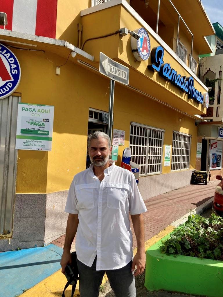 José Iván Romero, 44, stands in front of his pharmacy in downtown Comerío, Puerto Rico, on Wednesday.